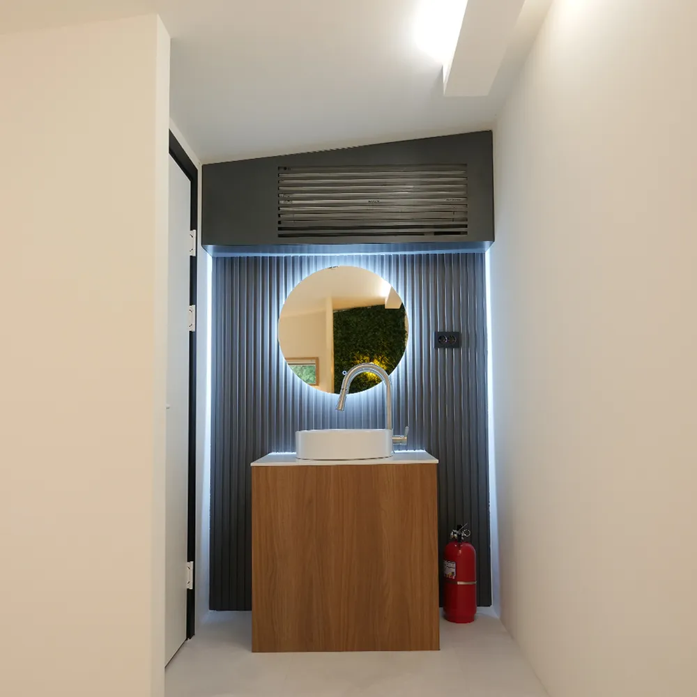 현관 옆 원형 거울과 세면대
